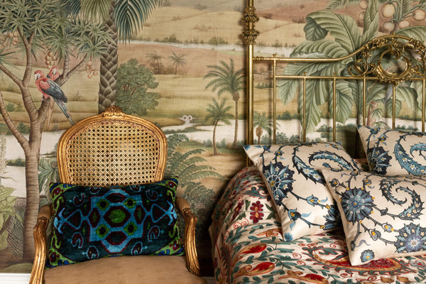 Luxurious hand-embroidered Clematis Vine with Blue Flowers Silk cushions displayed on a bed in a room.