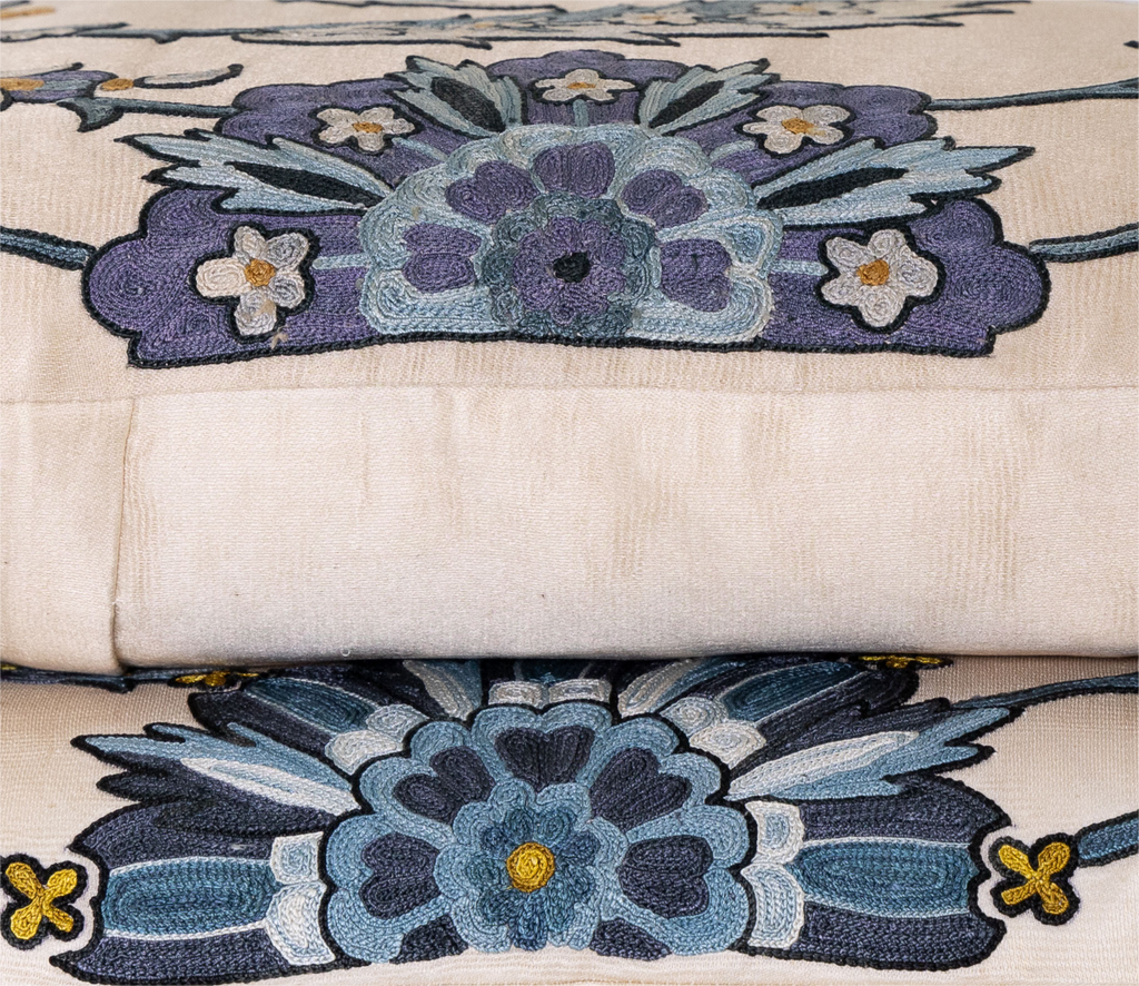 Side view of the luxurious hand-embroidered Clematis Vine with Small Centre Flower Silk cushion in two colour variants blue and purple. 
