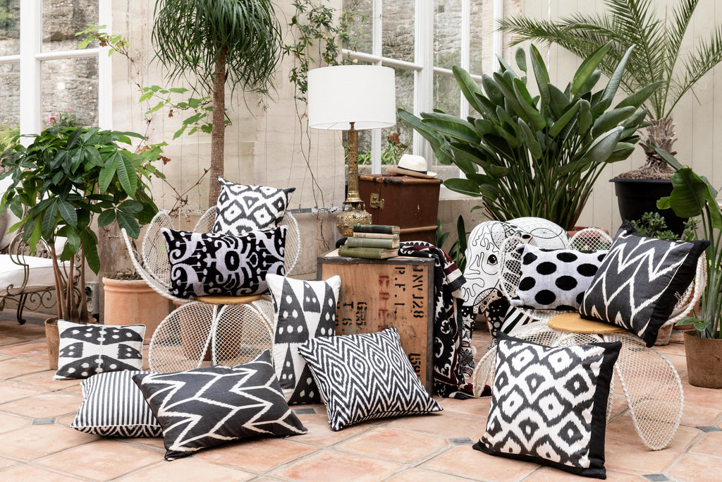 Image of various white and black patterned Silk Ikat cushions in a room.